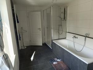 a bathroom with a tub and a walk in shower at Haus Berta in Spremberg +5 photos