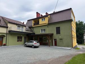 a small car parked in front of a house at Agroturystyka ''Dom Pod Karpiem'' in Zagórze Śląskie
