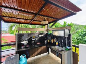 an outdoor kitchen with a counter and awning at Travis Post Homestay in Siquijor