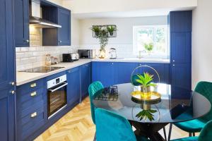 a kitchen with blue cabinets and a table and chairs at The Penthouse Retreat in Whitby +7 photos
