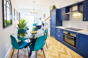 a kitchen with blue cabinets and a table and chairs at The Penthouse Retreat in Whitby