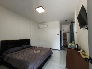 a bedroom with a bed and a flat screen tv at Home No 3 khanom in Ban Thung O