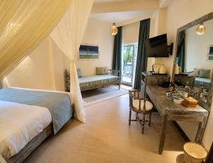 a bedroom with a bed and a desk and a couch at Soroi Blue - Diani Beach in Diani Beach
