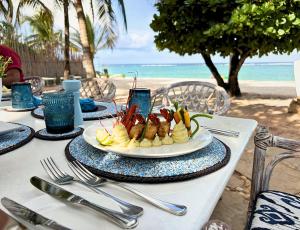 a plate of food on a table at the beach at Soroi Blue - Diani Beach in Diani Beach