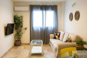 a living room with a couch and a glass table at Beach Palo Malaga in Málaga