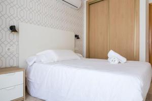 a bedroom with two beds with white sheets at Beach Palo Malaga in Málaga