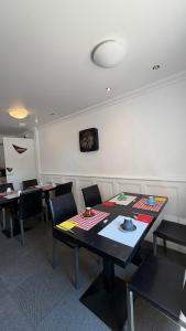 a dining room with tables and chairs and a clock on the wall at hôtel du grand sud in Ramonville-Saint-Agne