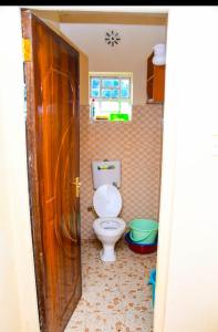a bathroom with a toilet and a window at Comfort Inn Nyeri in Nyeri +19 photos