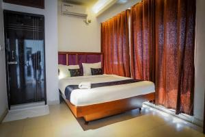 a bedroom with a bed in a room with curtains at Needs Bay Watch in Cox's Bazar +6 photos