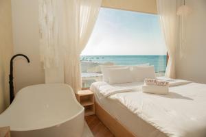 a bedroom with a bed and a window with the ocean at Hani Boutique Hotel Phú Quý in Cù Lao Thu +71 photos