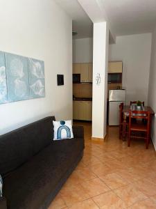 a living room with a couch and a table and a kitchen at Kapo Residence in Vlorë