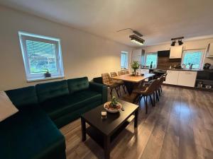 a living room with a green couch and a table at Chalupy Severní in Lobendava