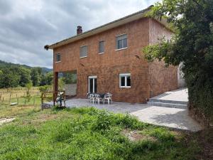 a brick house with a table and chairs in front of it at La Caleya de Ozanes in Ozanes