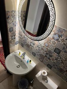a bathroom with a sink and a mirror at Phoenix Pyramids Inn in Banī Ghālib