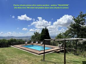 a swimming pool in a yard with a wooden deck and a swimming poolvisorangering at Masseria del bosco Poderuccio in Chianciano Terme