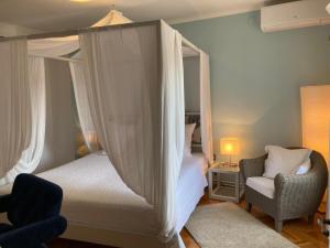 a bedroom with a canopy bed and a chair at Casa Mattea in Nerezine