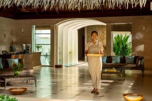 a woman standing in the lobby of a hotel at Niva Kuramathi Maldives in Rasdhoo +159 photos