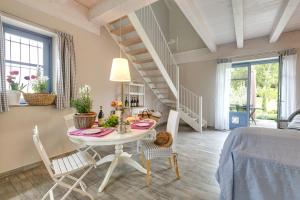 a dining room with a table and chairs and a staircase at Cascina Arcangelo Raffaele in Verduno
