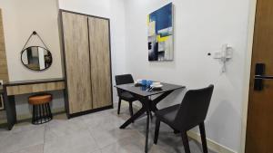 a dining room with a table and chairs and a mirror at Imperio A1910 Studio Bathtud Netflix Parking in Malacca