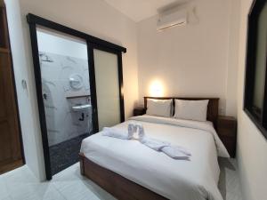 a hotel room with a bed with towels on it at Moonrise Rooms in Uluwatu