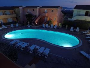 a large swimming pool with chairs and a slide at En Allusi Apartment in Badesi