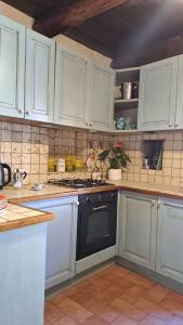 a kitchen with white cabinets and a black oven at Antico Borgo in Brugnato +34 photos