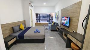 a bedroom with a bed and a tv and a couch at Imperio A1910 Studio Bathtud Netflix Parking in Malacca +4 photos