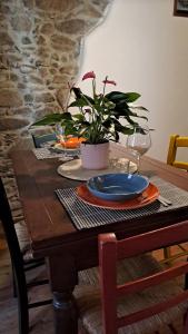 a wooden table with a plate and a plant on it at Antico Borgo in Brugnato