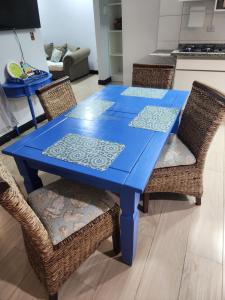 a blue table with wicker chairs in a kitchen at Casa Casal Itapoá in Itapoa