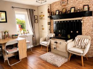 a living room with a desk and chairs and a fireplace at Daffodil Lodge in Sligo +24 photos
