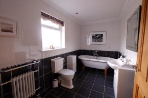 un bagno con un water, una vasca e un lavandino di Brae Cottage a Dunvegan Altre 8 foto