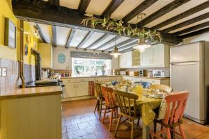 a kitchen with a table and chairs and a refrigerator at 6 Bed in Norwich oc-42594 in Shelton