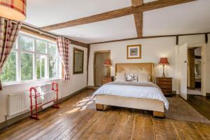 a bedroom with a large bed and wooden floors at 6 Bed in Norwich oc-42594 in Shelton