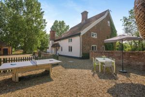 a backyard with a house and a table and an umbrella at 6 Bed in Norwich oc-42594 in Shelton