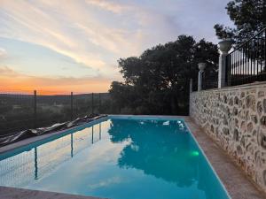 a swimming pool with a sunset in the background at Refugio Bella Luna in Ruidera