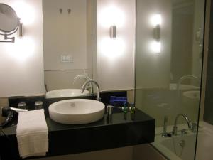 a bathroom with a sink and a glass shower at Hotel Palacio Albacete & SPA in Albacete