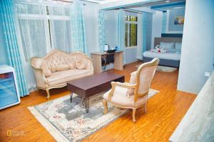 a living room with a couch chair and a table at Saffron Inn Luxury Hotel in Marsabit