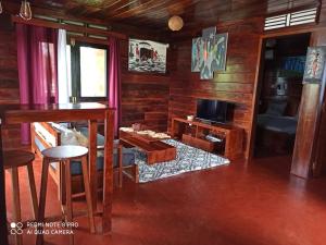 a living room with a table and a television at Chalet Bois Luxe in Nosy Be