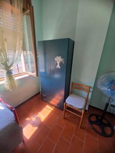 a room with a blue cabinet and a chair and a fan at Tronca Apartament Kalabria in Marina di Strongoli
