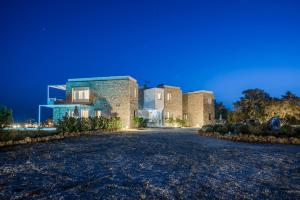 un gran edificio de ladrillo con una carretera delante de él en Cedar Bay Beachside Villas, en Palaiochóra