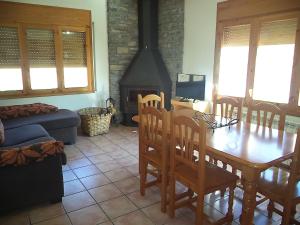 a living room with a wooden table and a fireplace at Casa la Cuadreta in Calvera