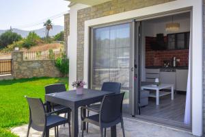 a patio with a table and chairs and a kitchen at Kargı Suites Datça in Datca