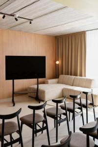 a hotel room with a bed and chairs and a flat screen tv at Hotel Node in Swarzędz