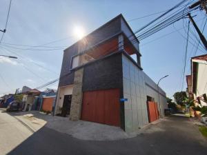 a building with a red door on a street at Teras Watu Tegal in Tegal