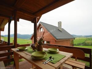 a wooden table with green bowls on top of a house at Domki Czterech Braci in Grywałd