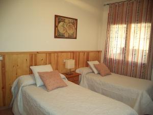 a room with two beds and a picture on the wall at Casa la Cuadreta in Calvera