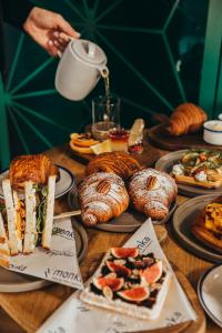a table topped with plates of food and pastries at ToRUŃ ApartHotel z widokiem na Wisłę i Krzywą Wieżę in Toruń