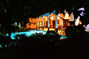 a house with a swimming pool at night at Lucas in Bentota
