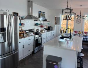 a kitchen with white cabinets and a stainless steel refrigerator at The View suites and breakfast in Triton, Newfoundland in Pilleyʼs Island