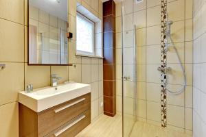 a bathroom with a sink and a shower at Villa Arkodes in Gdańsk